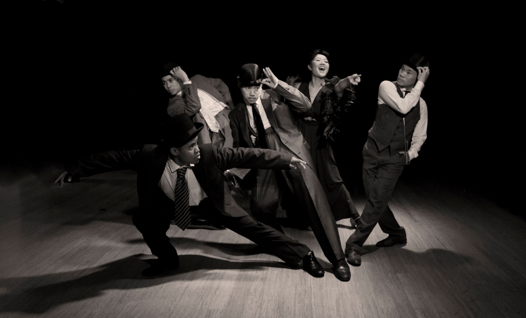 Group of performers in business suits lean away from one another