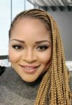 Close up of a woman in braids facing the camera.