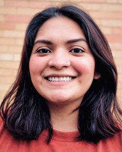 Woman with shoulder length brown hair smiles at the camera